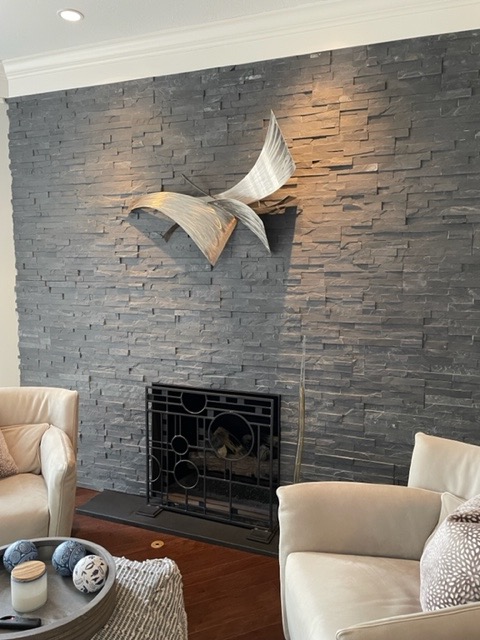 slate gray stone fireplace with warm neutral furniture